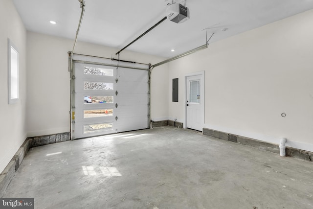 garage with a garage door opener, electric panel, and baseboards