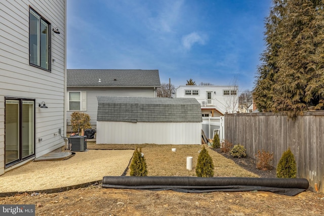 view of yard featuring a storage unit, an outdoor structure, fence, and cooling unit