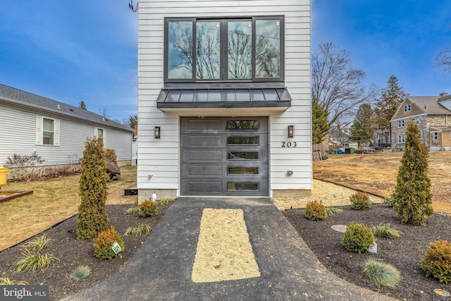 exterior space with metal roof, aphalt driveway, and a standing seam roof