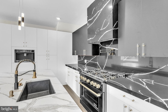 kitchen featuring stainless steel stove, oven, a sink, wall chimney exhaust hood, and tasteful backsplash