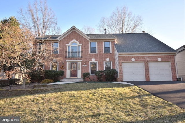 view of front of house with aphalt driveway, a front yard, a shingled roof, a garage, and brick siding