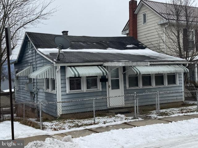 view of front of home featuring a fenced front yard and a chimney