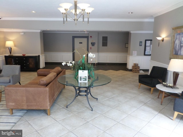 tiled living room with a wainscoted wall, ornamental molding, a chandelier, and a decorative wall