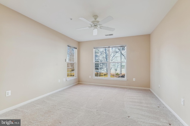 carpeted empty room featuring visible vents, baseboards, and ceiling fan