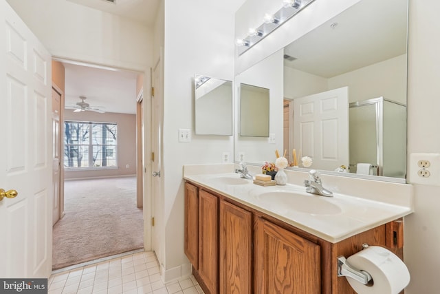 bathroom with double vanity, visible vents, a shower with door, and a sink