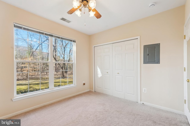 unfurnished bedroom featuring visible vents, electric panel, a closet, carpet flooring, and baseboards