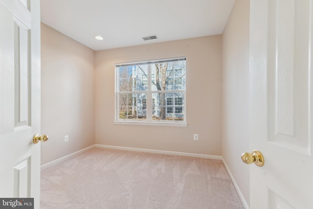 carpeted empty room featuring visible vents and baseboards