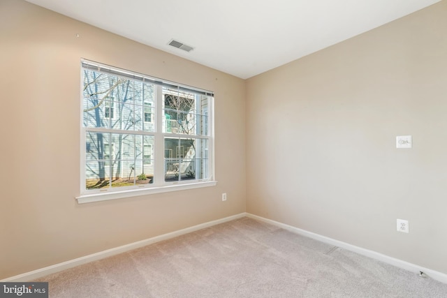 empty room featuring visible vents, baseboards, and carpet flooring