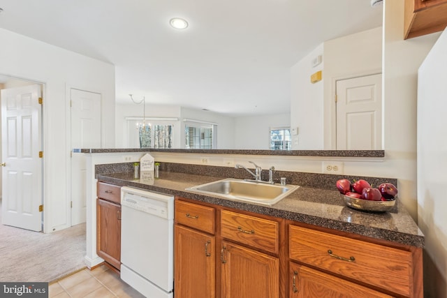 kitchen featuring brown cabinets, light carpet, a sink, light tile patterned floors, and dishwasher