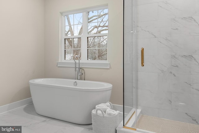 full bathroom featuring marble finish floor, a shower stall, baseboards, and a soaking tub