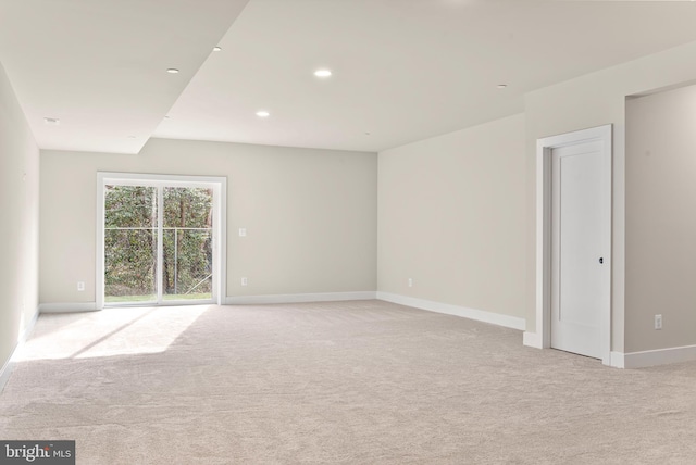 spare room with baseboards, recessed lighting, and light colored carpet