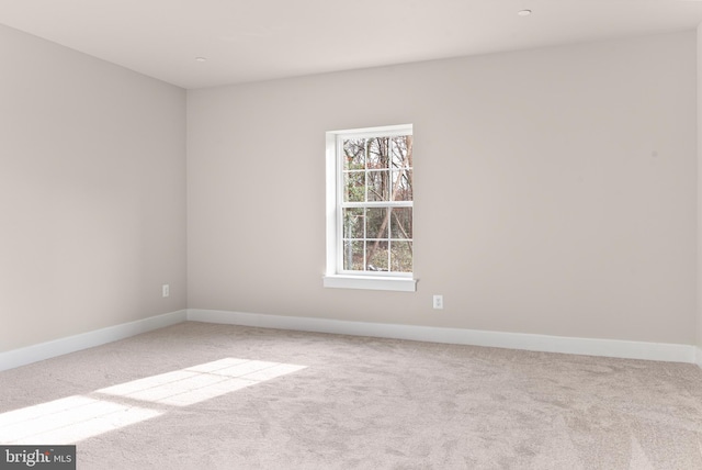 carpeted spare room featuring baseboards