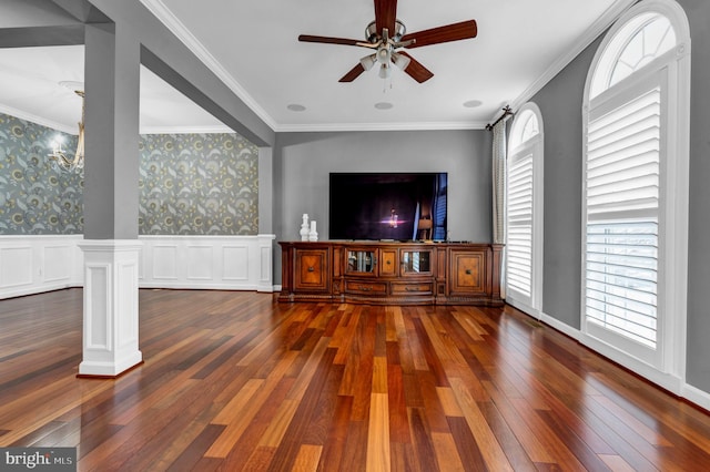 living area with dark wood-style floors, ornamental molding, wallpapered walls, and wainscoting