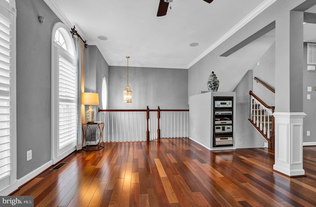 unfurnished room with a healthy amount of sunlight, hardwood / wood-style flooring, and crown molding