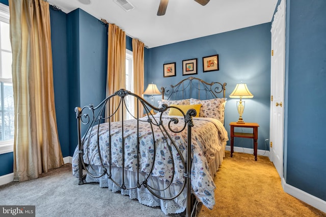 carpeted bedroom with baseboards, visible vents, and a ceiling fan