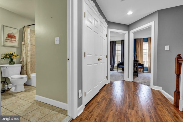 hallway with wood finished floors and baseboards