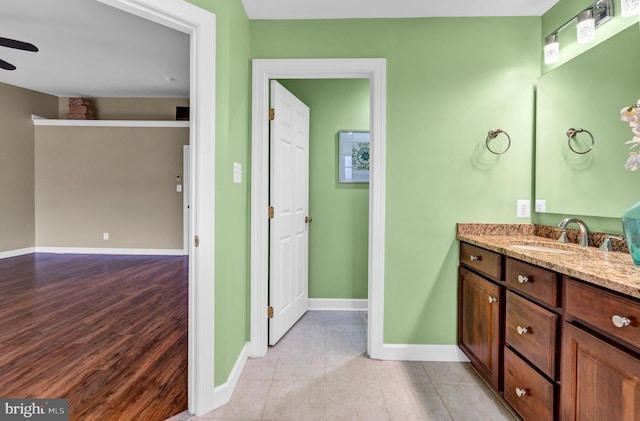 bathroom with tile patterned flooring, ceiling fan, vanity, and baseboards