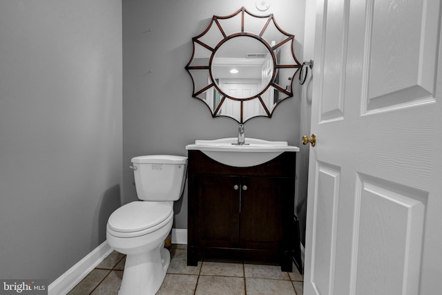 half bathroom with toilet, tile patterned flooring, vanity, and baseboards