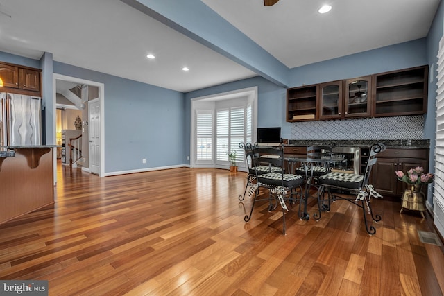 home office with visible vents, baseboards, light wood-style floors, beam ceiling, and recessed lighting