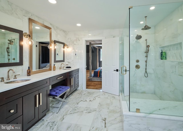 bathroom with marble finish floor, a sink, a marble finish shower, and double vanity