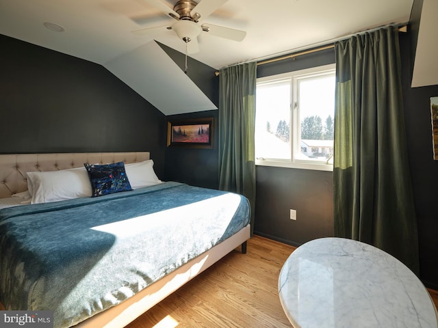 bedroom with a ceiling fan, lofted ceiling, and wood finished floors