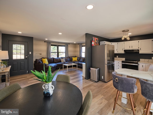 dining area featuring light wood finished floors and recessed lighting