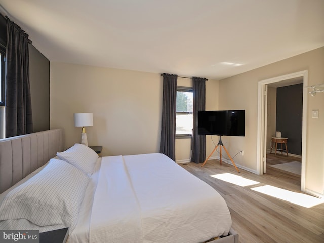 bedroom with wood finished floors and baseboards