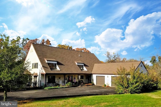 view of front facade with a garage, a front lawn, and aphalt driveway