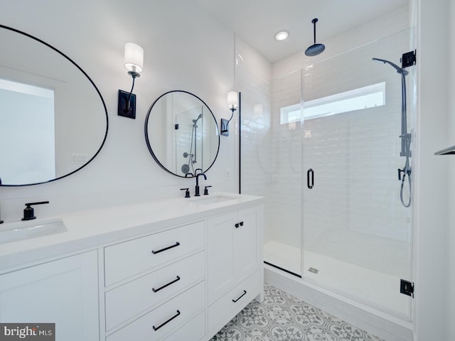 full bathroom with double vanity, a stall shower, tile patterned flooring, and a sink