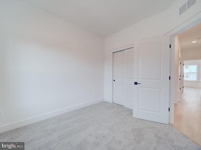 unfurnished bedroom featuring a closet, carpet, visible vents, and baseboards