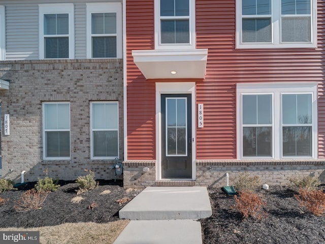 entrance to property featuring brick siding