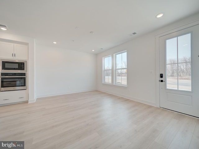 interior space featuring light wood-style flooring, visible vents, baseboards, and recessed lighting