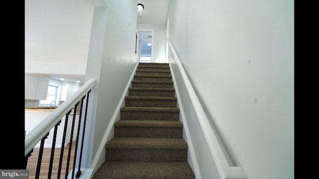 stairs featuring wood finished floors and baseboards