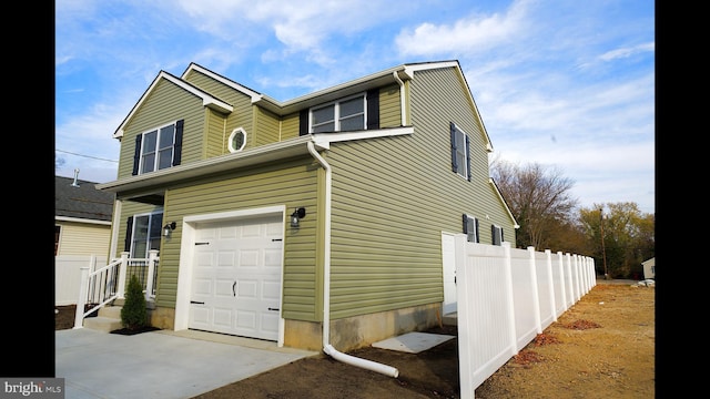 view of side of property with a garage and fence