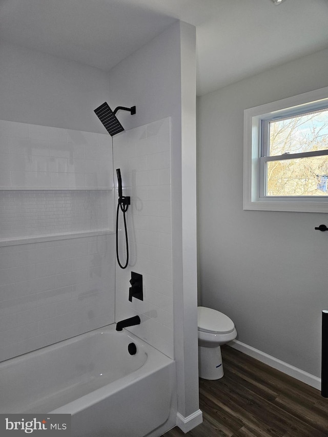 bathroom featuring shower / bathtub combination, wood finished floors, toilet, and baseboards