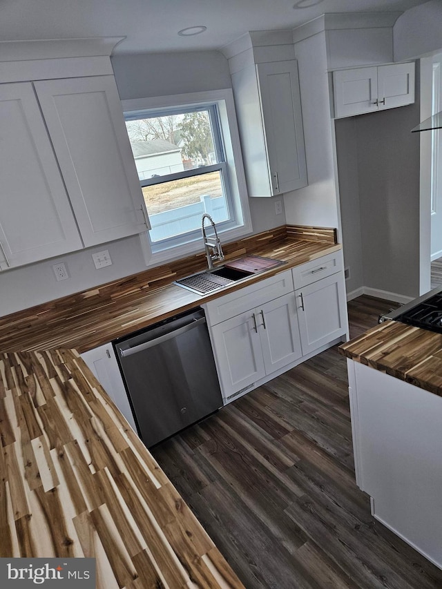 kitchen with butcher block countertops, a sink, stainless steel dishwasher, and dark wood-style floors