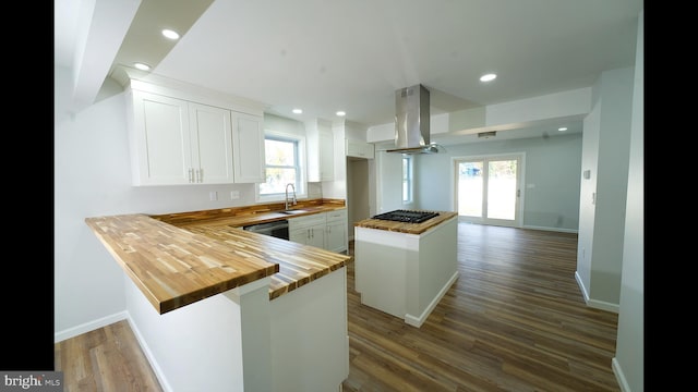 kitchen with black gas cooktop, island range hood, wood counters, white cabinetry, and dishwasher