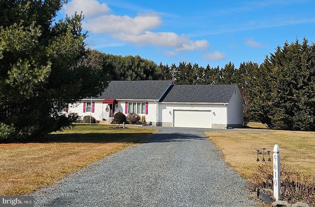 ranch-style home with a garage, gravel driveway, and a front yard