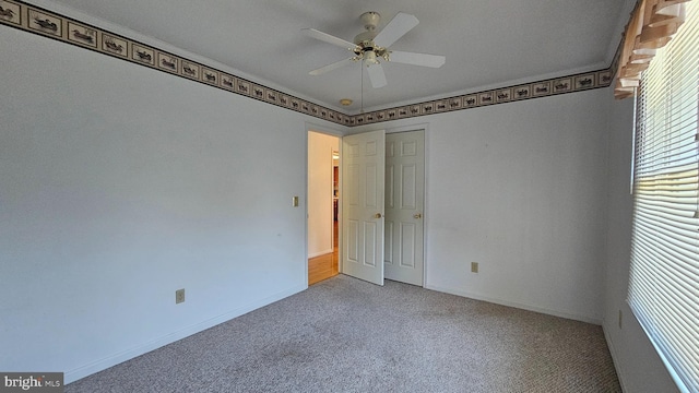 unfurnished room featuring carpet flooring, a ceiling fan, and baseboards