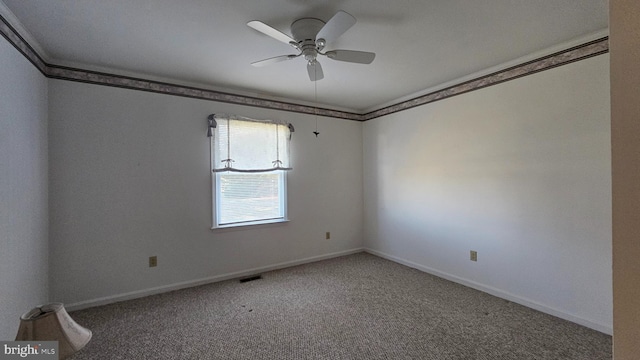 carpeted spare room featuring baseboards, ornamental molding, and a ceiling fan