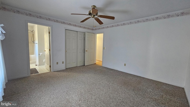 unfurnished bedroom with carpet floors, ornamental molding, a closet, and ensuite bath