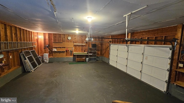 garage with wood walls and a garage door opener