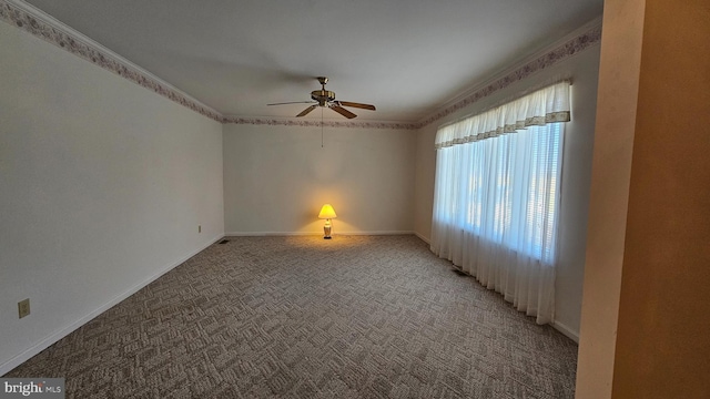 empty room with light colored carpet, crown molding, baseboards, and ceiling fan