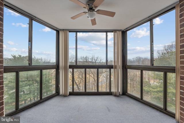 unfurnished sunroom with a ceiling fan