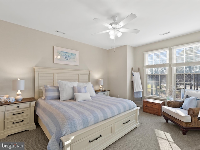 bedroom with visible vents, light colored carpet, and ceiling fan