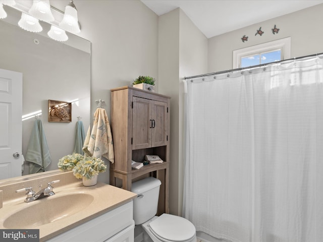 full bathroom featuring a notable chandelier, toilet, curtained shower, and vanity