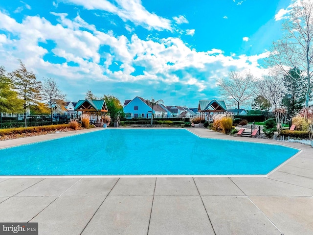 view of pool with a swimming pool, a residential view, and fence