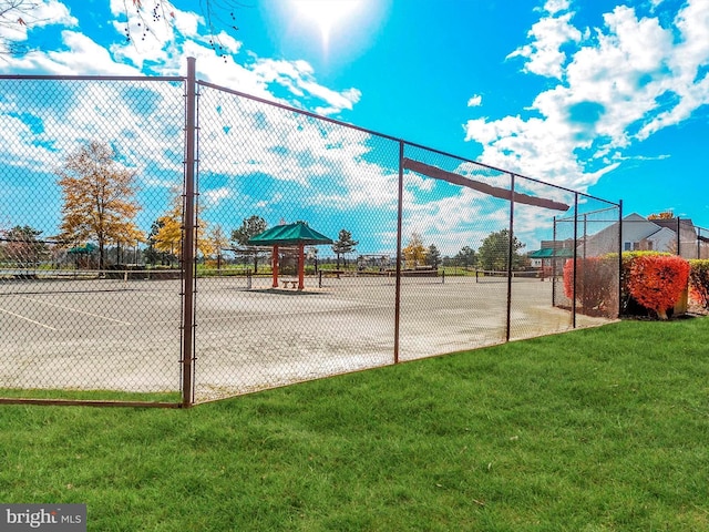 view of home's community featuring a yard, a tennis court, and fence