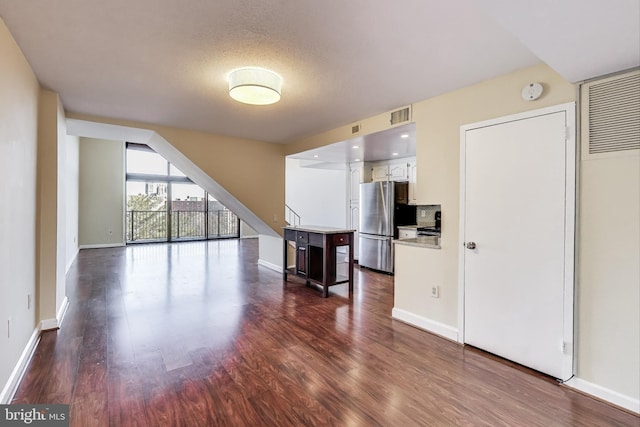 3101 New Mexico Ave NW Unit 847, Washington, DC 20016 - unfurnished living room with dark wood-style floors, visible vents, and baseboards