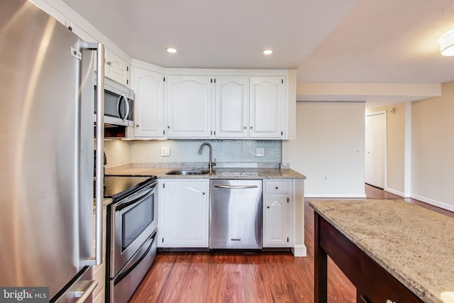 3101 New Mexico Ave NW Unit 847, Washington, DC 20016 - kitchen featuring tasteful backsplash, light stone countertops, stainless steel appliances, white cabinetry, and a sink